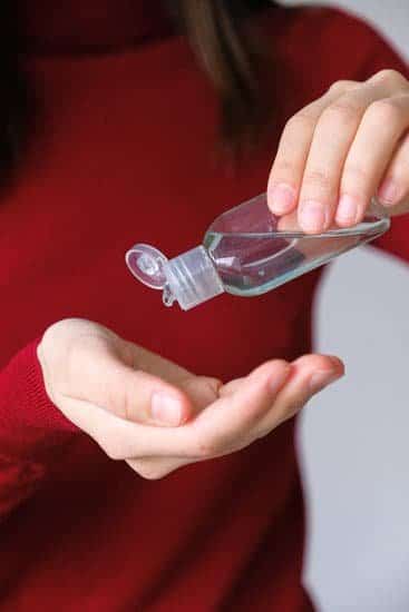 Hand sanitiser being tipped from a bottle into hands