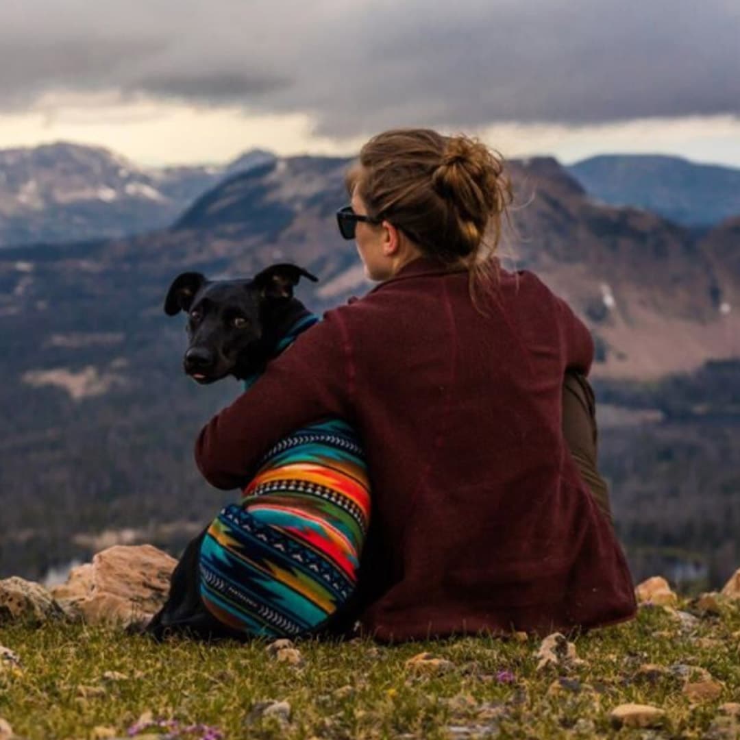 Woman and black dog overlooking mountains